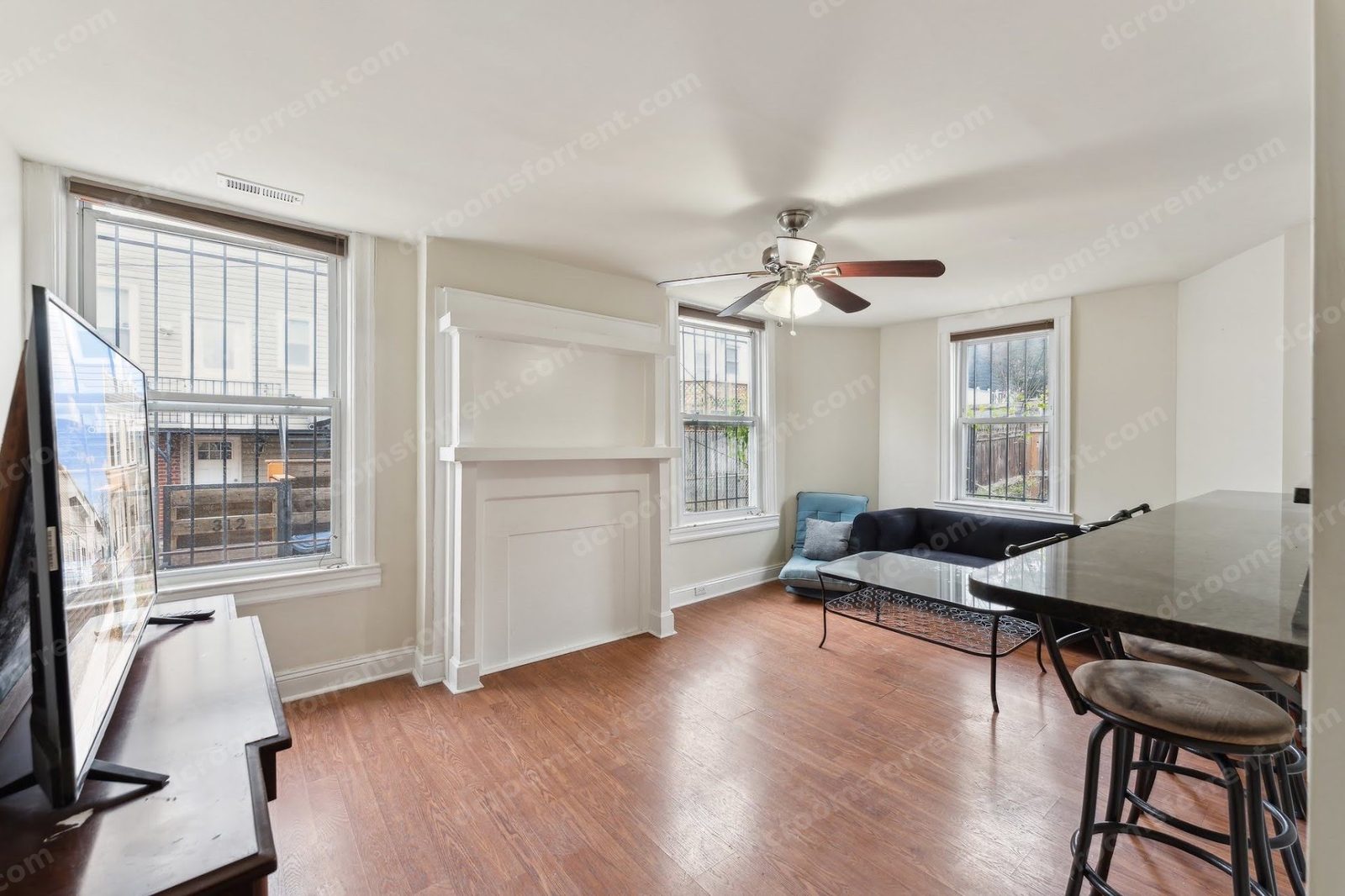 Shared living room: couch, coffee table, TV, fireplace, and bar seating