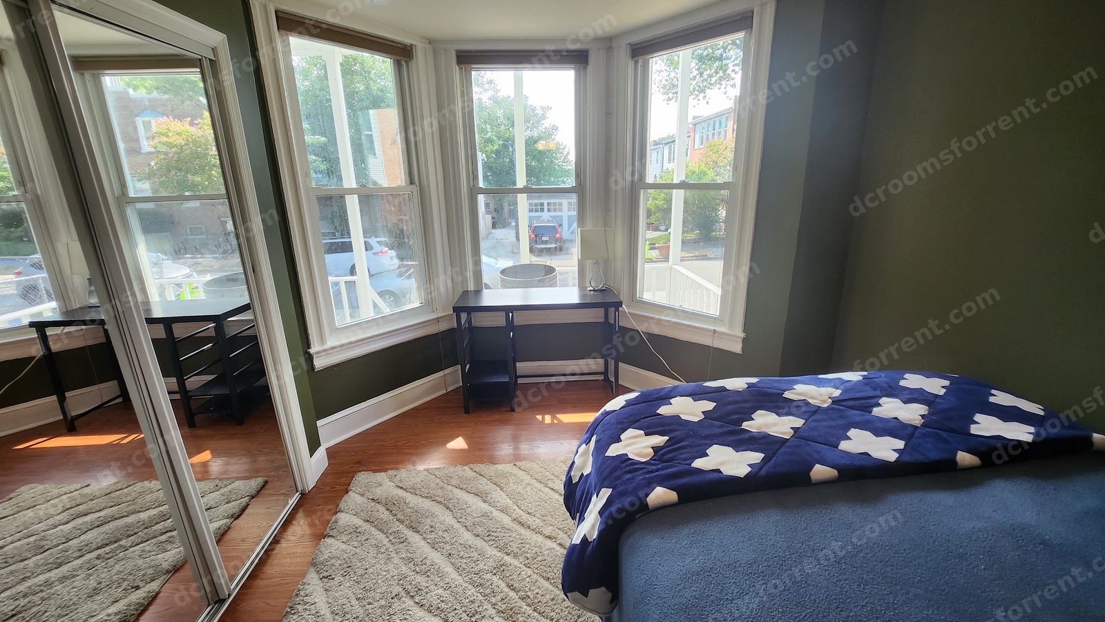 Delta Room: bay window with desk and lamp, bed with blue bedding