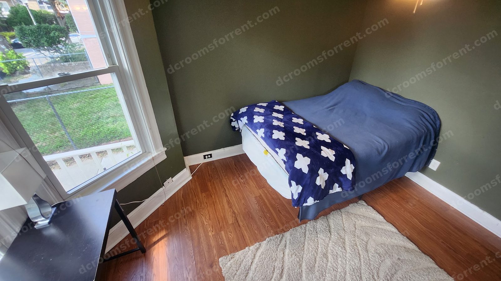 Delta Room: bed with blue bedding, desk under the bay window, ceiling fan