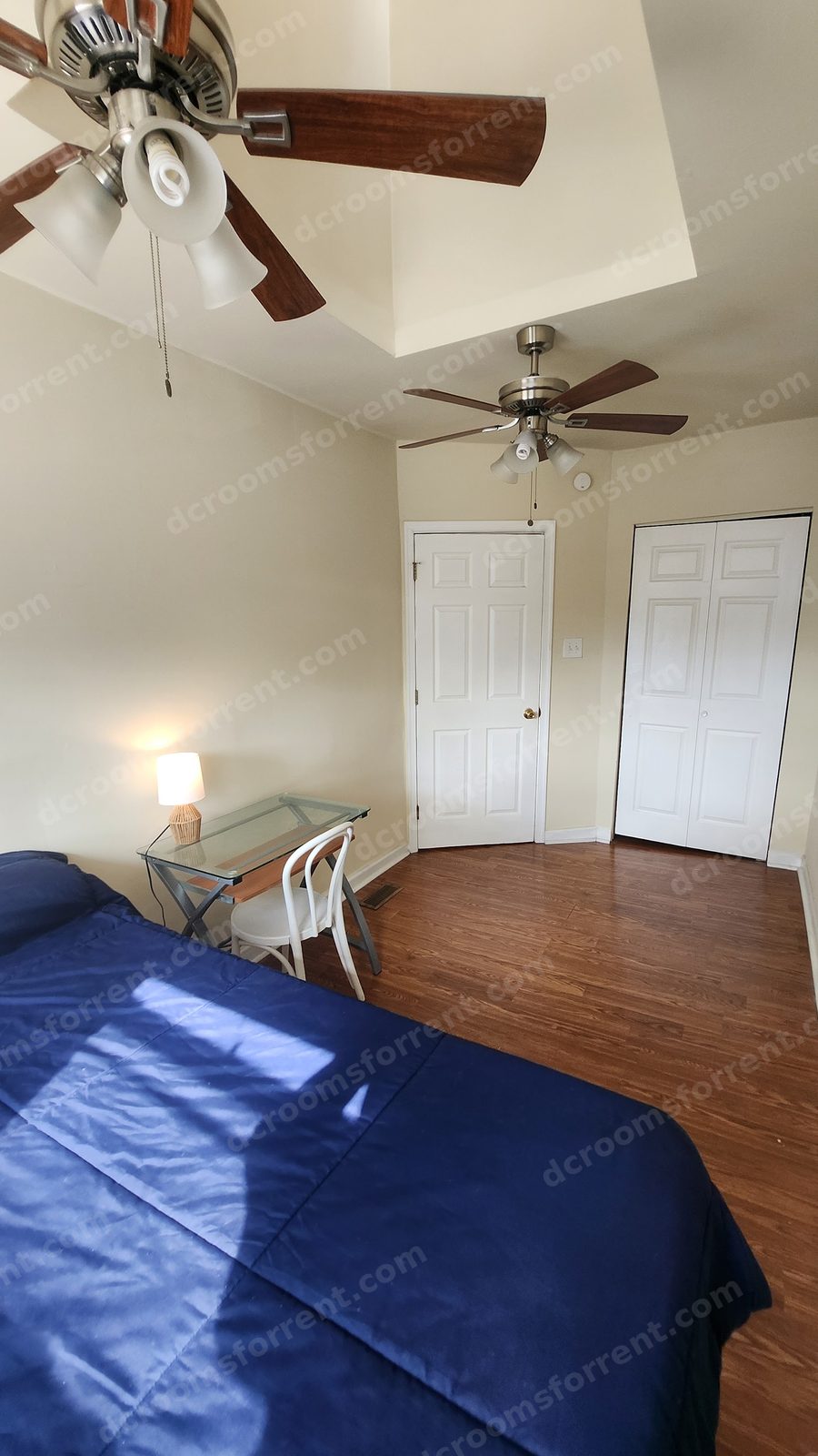 Foxtrot Room: blue bedspread close-up, glass desk with lamp and chair, built-in closet doors