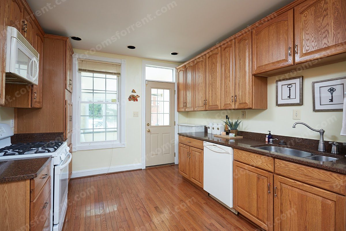 Shared kitchen: double sink, dishwasher, and oak cabinets.