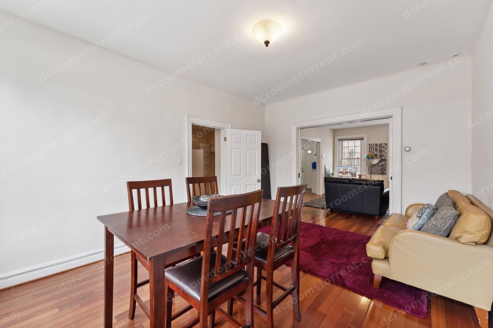 Shared dining room with wooden table and chairs opening onto the living room.