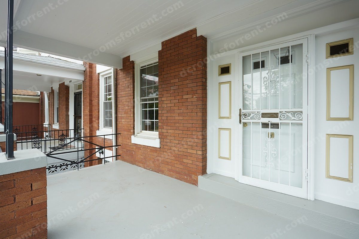 Front porch with brick facade and white security door.