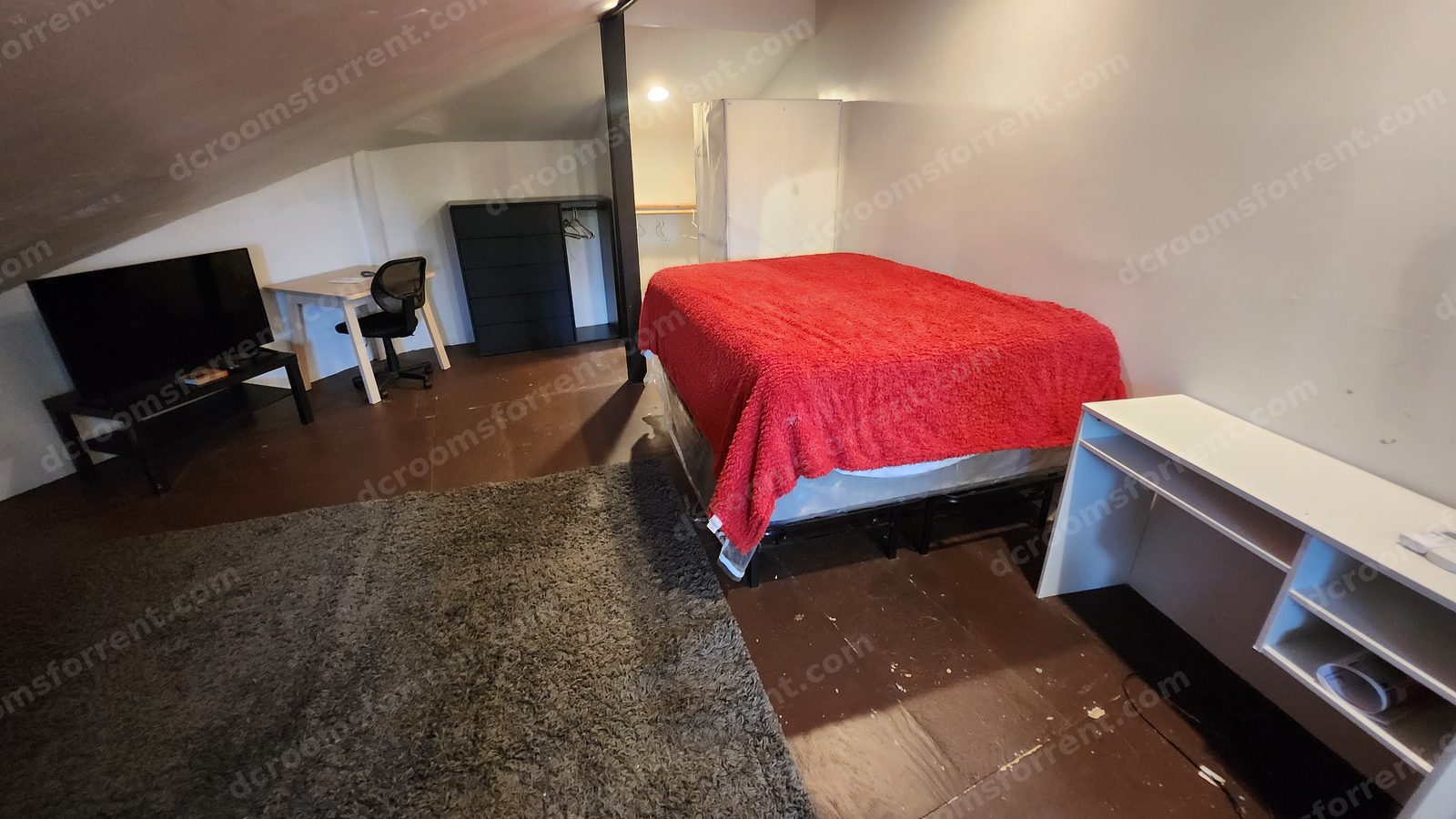Washington Room: bed with red blanket, flat-screen TV, desk, and dresser.
