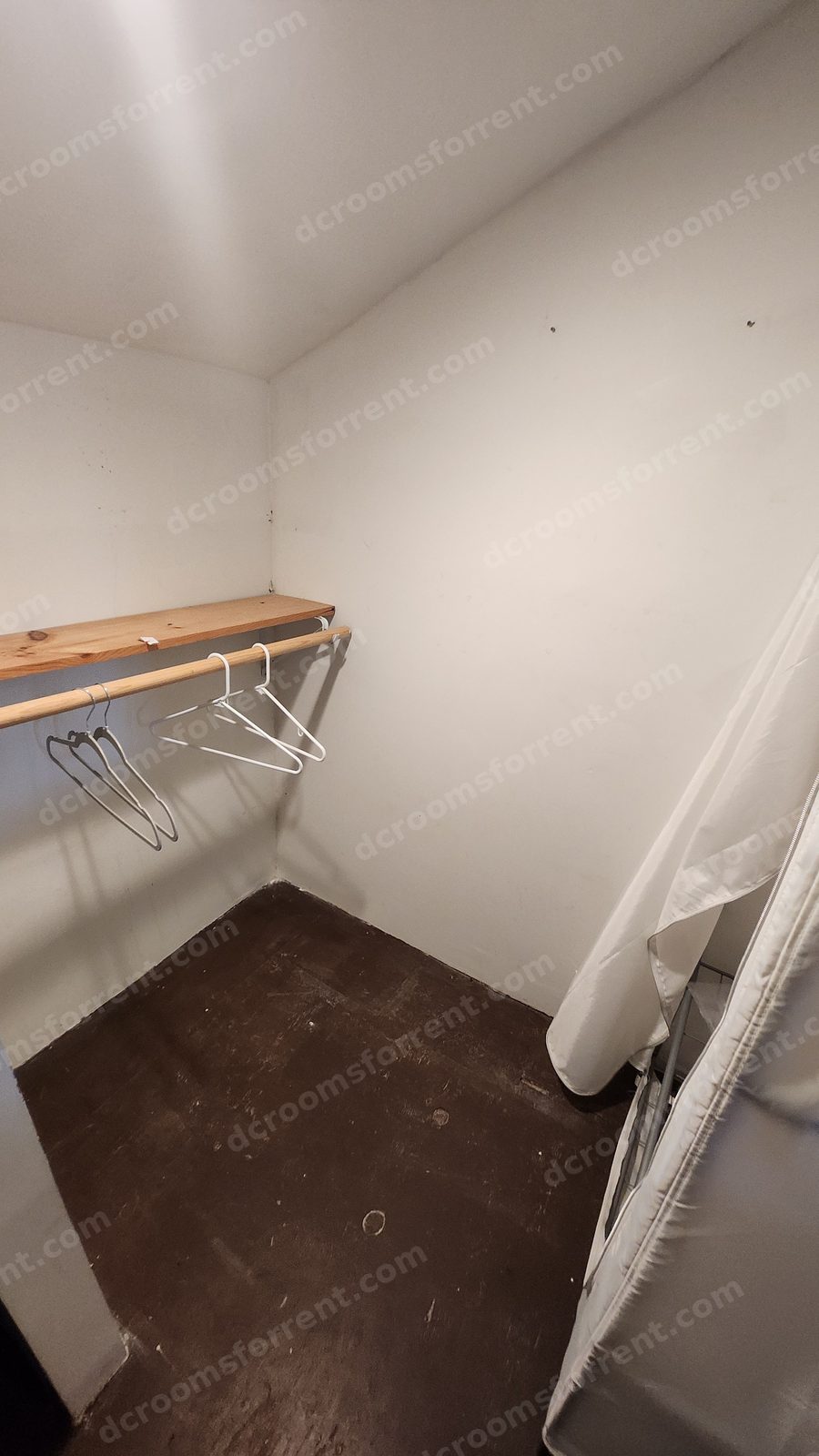 Washington Room closet area with hanging rod, shelf, and garment storage.
