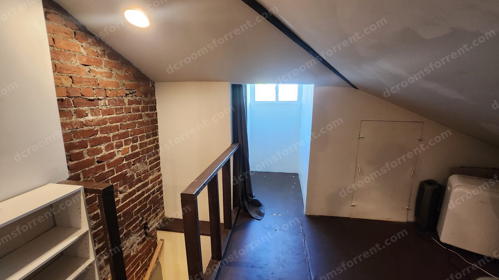 Exposed brick wall, stair railing, and storage doors in the Washington Room.