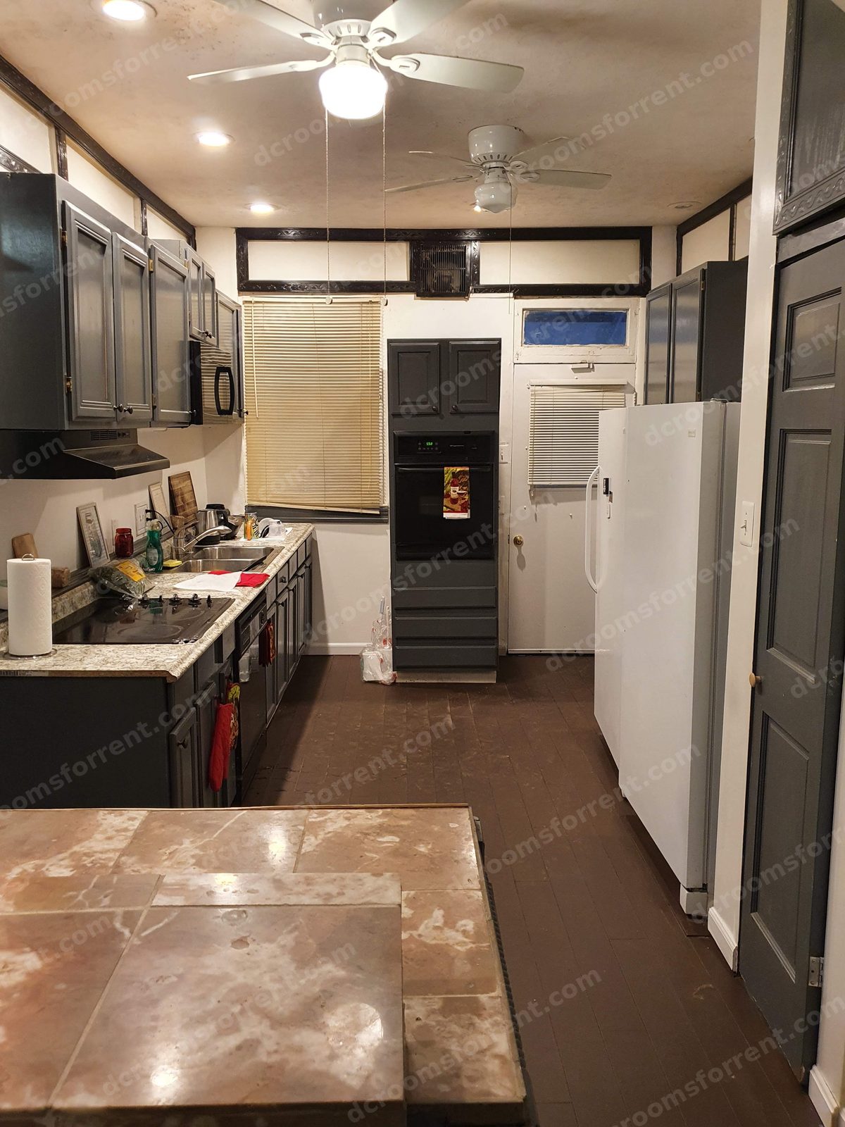 Shared kitchen: full-size stove, double sink, refrigerator, and island counter.