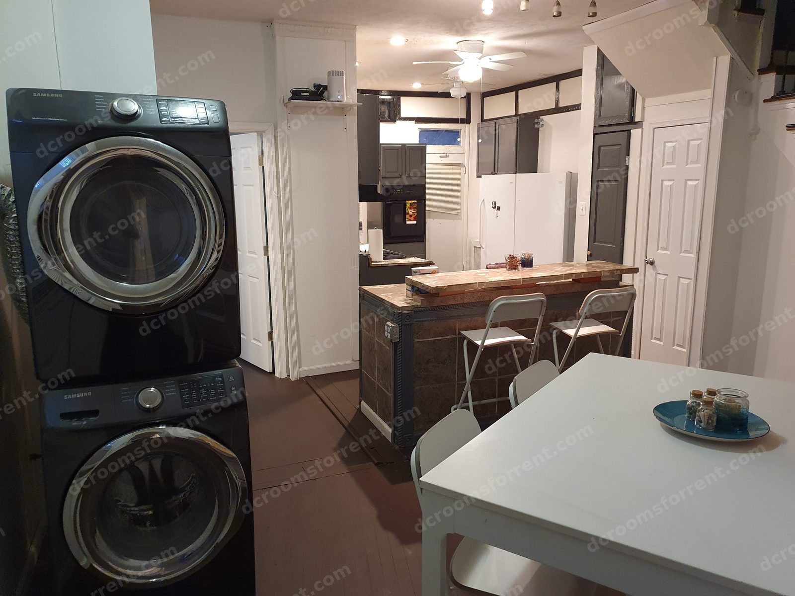 Dining area with table, breakfast bar seating, and stacked washer and dryer.