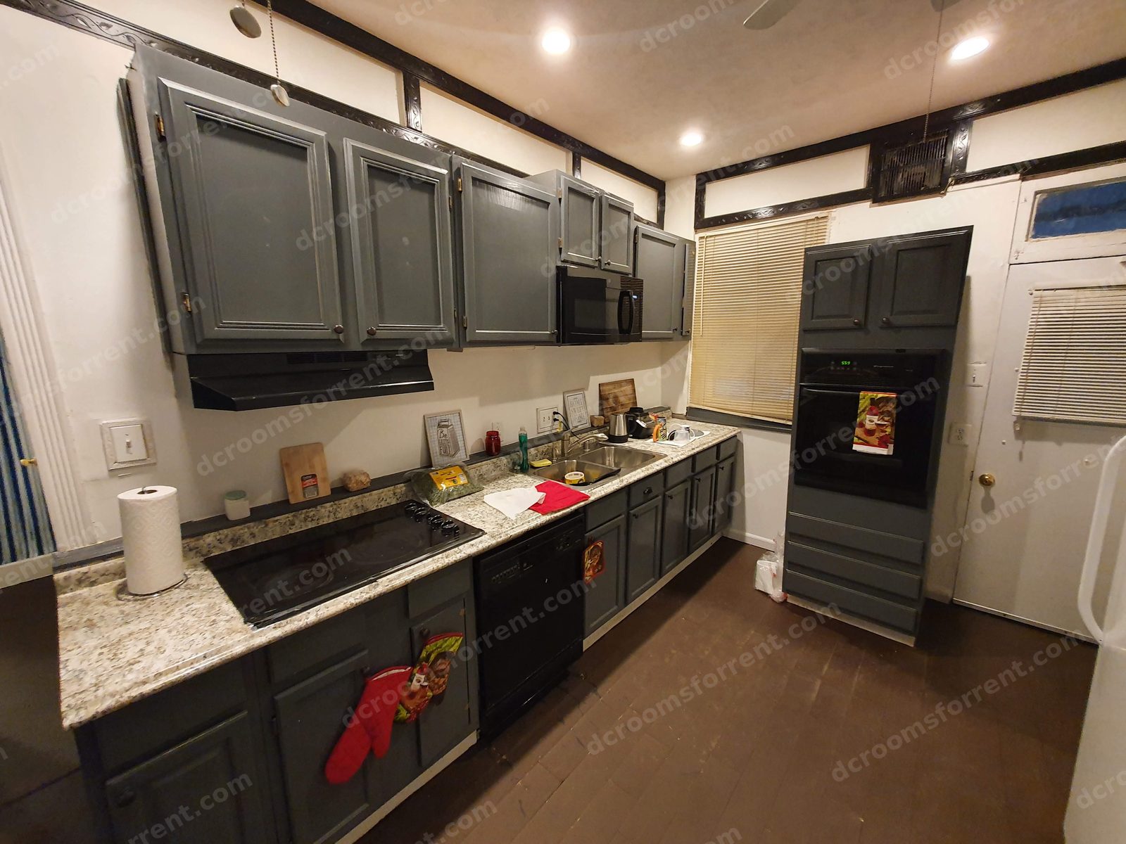 Shared kitchen work wall: stove, sink, dishwasher, and double oven.