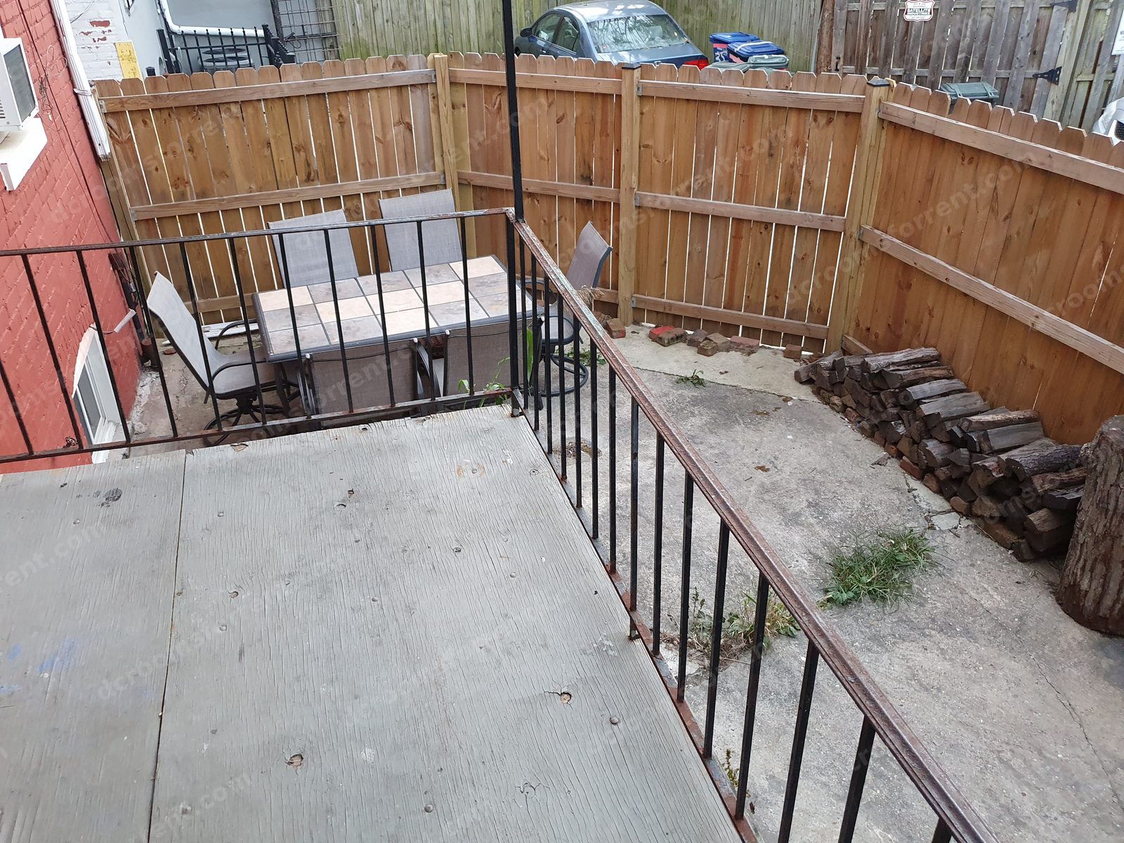 Fenced backyard with patio table and chairs.